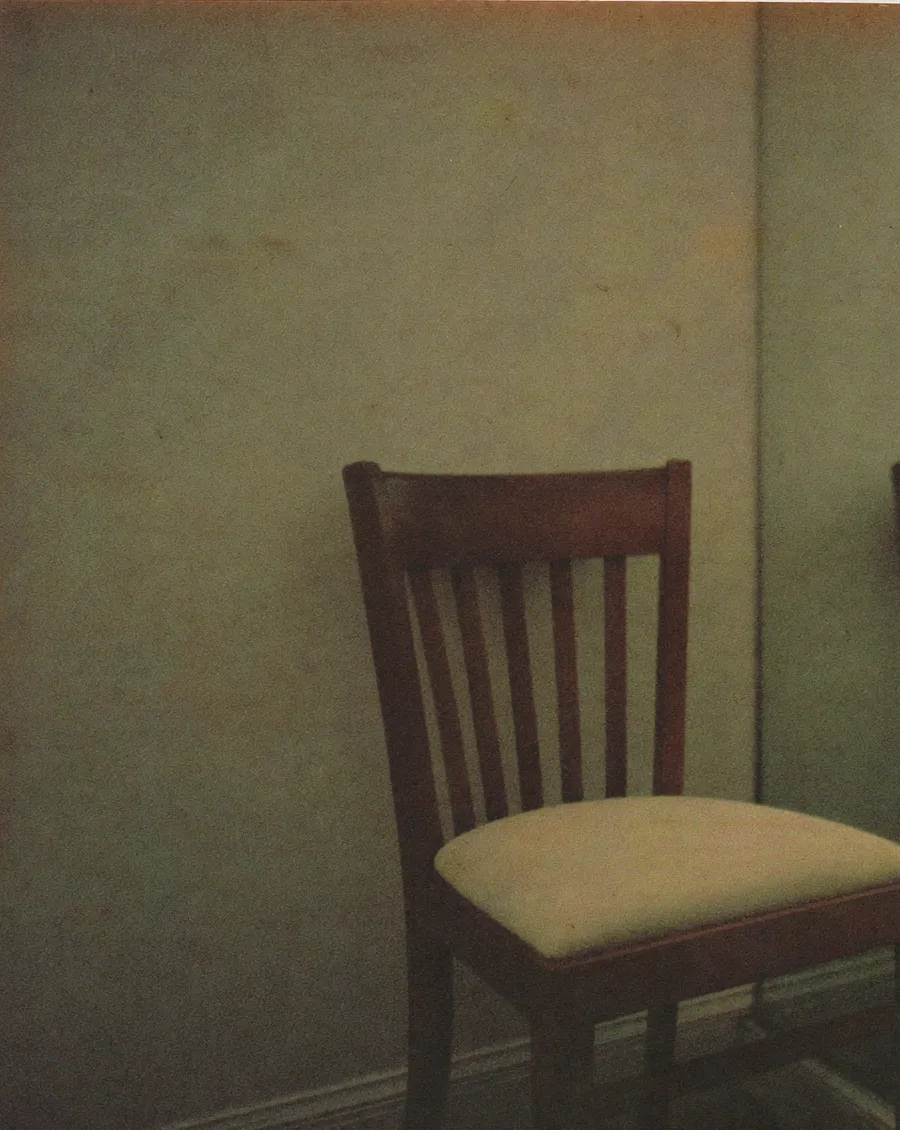 A woman in her forties standing unnoticed at a busy counter while the assistant serves past her, the everyday experience of feeling invisible in midlife