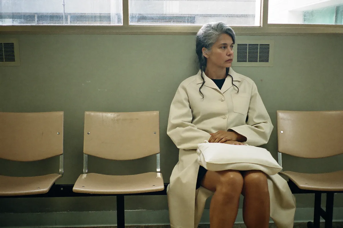 A woman in her forties waiting in a clinic to have her symptoms looked at rather than working them out alone